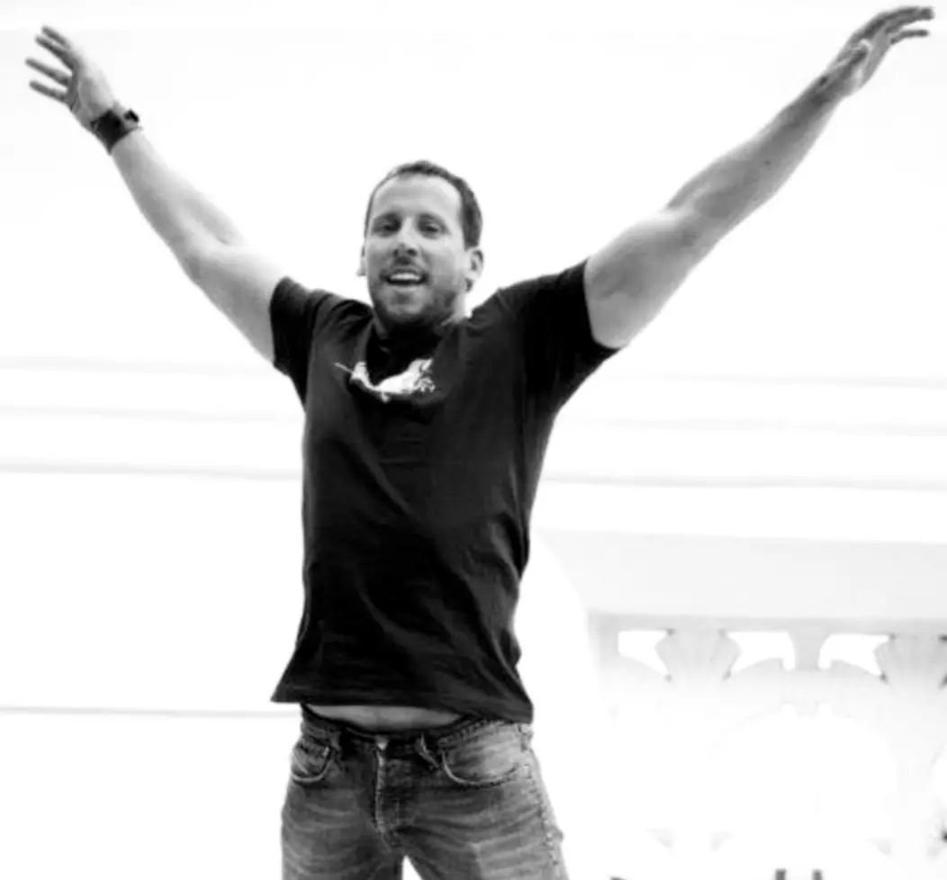 Man jumping joyfully in black and white.